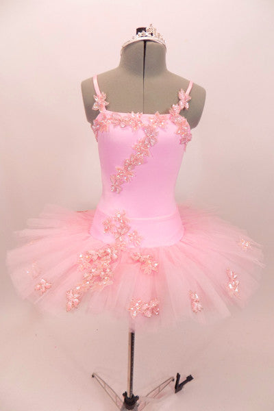 Pink platter tutu is hand tacked with zip-up bask & camisole leotard. Bodice, bask & tutu are adorned with beaded floral appliques. Comes with crystal tiara. Front