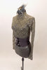 Taupe-grey lace sequined long-sleeved half top has high neck collar. Top is accompanied by matching glitter briefs and a feather and glitter hair accessory. Left side