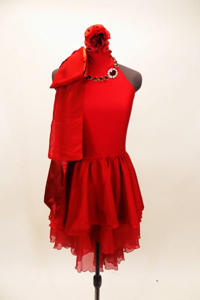 Red high neck, halter dress has attached skirt in layers of red chiffon. There is an attached red jeweled necklace and large satin bow that sits on right shoulder. Comes with red, crystaled hair accessory. Front