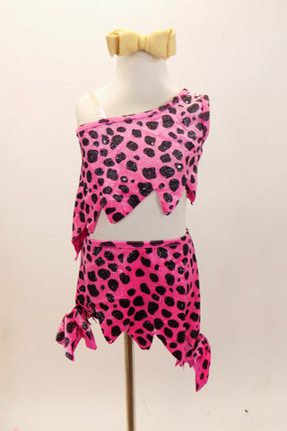 Pink and black 2 piece caveman print costume with one shoulder, jagged edged, crop-top. Comes with matching jagged edged skirt and bone hair accessory. Front