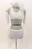 White sequined halter bra top is attached to white shorts by two straps that originate below the bust  by crystal ring accessory and attaches at the side of hips. There is an attached hip to hip bustle comprised of white and silver boa feathers. Comes with matching feather hair accessory and shiny white gauntlets. Front