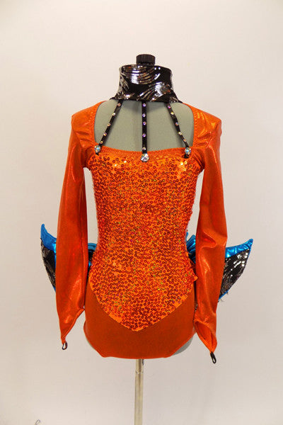 ong sleeved orange leotard that has square neckline and gold sequined front. There is a wide black sequined collar that attached to open neckline by three crystal covered straps. Sleeves have an attached padded blue fin with sequin accent. The black bustle is layers of sequin edged black tulle beneath a metallic blue ruffle. The finishing touch is a large black mesh fin that is attached securely to the center of the back. Front