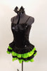 Black sequined & boned corset dress has grommet & lace  back. Has attached skirt with layers of ruffled green & black satin. Has separate panty & hair accessory. Left side