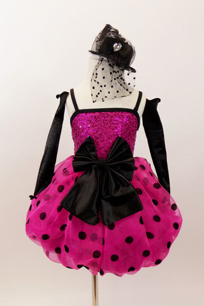 Hot pink sequined bodice has pink-black polk-a-dot bubble skirt with black satin front bow. Comes with black satin gauntlets and glittery black veiled top-hat. Front