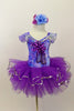 Blue and purple floral leotard has chiffon ruffle sleeves, silver trim & large purple applique on bodice. Has purple pull-on tutu & matching floral hair accessory. Front