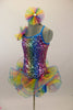 Rainbow colored square-sequined camisole leotard has attached rainbow colored, curly organza ruffle skirt. Comes with matching rainbow hair accessory.  Feft side