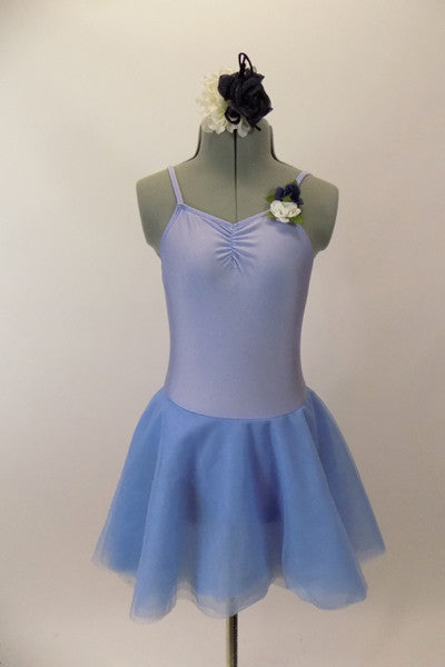 Pale blue leotard dress with floral accent has low back with looping cross strap design at lower back. The attached skirt is sheer layers of pale blue. Comes with hair accessory. Front