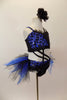 Blue and black costume is a two-piece joined at the front by cross straps. The top is black & blue animal print. Black briefs have black & blue tulle bustle. Has black floral hair accessory. Right side