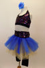 Black capri legging is attached to a gold & blue tutu with colorful sparkle waistband. The halter half top matches the waistband. Has blue floral hair accessory. Left side