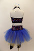 Black capri legging is attached to a gold & blue tutu with colorful sparkle waistband. The halter half top matches the waistband. Has blue floral hair accessory. Back