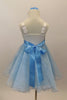 White satin bodice dress has front ruffle. Sparking blue organza rests over blue tulle. Wide blue satin waist sash has crystal heart accent. Has rose hair clip. Back