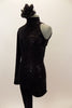 Black high neck unitard has one long leg and one sleeve & open back. There is a swirling pattern of black sequin along  left side. Has black hair accessory. Left side