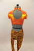 Bright orange metallic high neck half top has keyhole back. Accompanied by metallic orange leggings with a black & silver splatter pattern & black baseball cap. Back