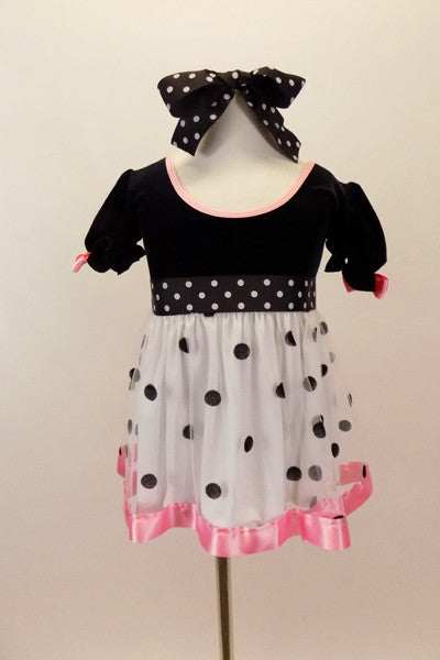 Dress has black velvet bodice with pouf sleeves, pink satin trim & bows. Skirt is white mesh with black dots & pink satin trim. Has dotted waist sash & hair bow, Front