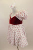 Dress has red velvet sweetheart bodice with open back and small crystal heart accent. The pouf sleeves and skirt are flowy white mesh with small red hearts. Comes with bow hair accessory. Left side