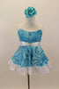 Camisole leotard dress has swirls of blues on aqua base. Has a white petticoat and wide lace trim. White satin waist sash had a crystal heart. Has floral hair accessory. Front