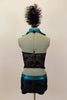Black & gold lace halter has separate ruffled high neck turquoise collar. Lace shorts have turquoise piping & button accents. Has large feather hair accessory. Back