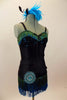 Roaring 20s style costume has bodice with lace bra & green-turquoise fringe. Black briefs have the matching fringe and a huge round crystal brooch at hip. Has turquoise feather hair piece. Right side