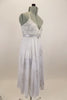 White leotard dress has long skirt with silver floral pattern. Empire waist has silver sequined waistband with crystal brooch. Has matching  hair accessory. Right Side