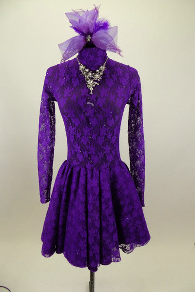 Purple lace high neck, long sleeved open back dress has large jeweled crystal attached necklace. Comes with large matching purple hair accessory. Front