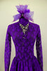 Purple lace high neck, long sleeved open back dress has large jeweled crystal attached necklace. Comes with large matching purple hair accessory. Front zoomed