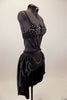 Black crystal covered bra is attached to bottom by a series of straps that converge to a point. Shorts have front chain detail under an open front satin skirt. Right side