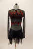 Black long sleeved sheer leotard has front bust panel in flame pattern edged in red sequins. Black shorts have flame pattern repeated on back with sheer bustle. Front