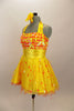 Orange & yellow paillettes, feathers & crystals adorn yellow satin dress with halter neck, skirt with yellow base on orange petticoat & matching hair accessory. Left side