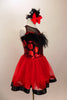 Dress has bodice with sweetheart neck polka dots & black mesh covered with crystals & feather trim. Skirt is red tricot with black satin hem. Has hair accessory. Right side