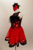 Dress has bodice with sweetheart neck polka dots & black mesh covered with crystals & feather trim. Skirt is red tricot with black satin hem. Has hair accessory. Left side
