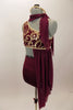 Maroon costume has golden brocade pattern, gold binding and an attached stretch-mesh scarf & asymmetrically draped skirt. Has high-waisted shorts & hair accessory. Left side