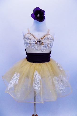 White lace appliqués adorn the champagne stretch-satin camisole bodice & attached gold sparkle tutu skirt. Has wide eggplant cummerbund with large back bow. Has matching hair accessory. Front