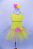 Sequin mesh overlays front bodice of  camisole leotard with silver braid trim. Rainbow sparkle tulle rests on yellow tricot tutu. Roses accent waist and hair. Front