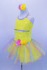 Sequin mesh overlays front bodice of  camisole leotard with silver braid trim. Rainbow sparkle tulle rests on yellow tricot tutu. Roses accent waist and hair. Left side