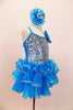 Hologram sequins cover stretch satin bodice of turquoise ruffled camisole dress. Jeweled rosettes accents the left shoulder and hair matching hair accessory. Right side