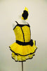 Yellow sequin leotard has black velvet accents with crystals. Black satin rosettes accent the waist & hair accessory. Has ruffle layer skirt with black trim. Right side