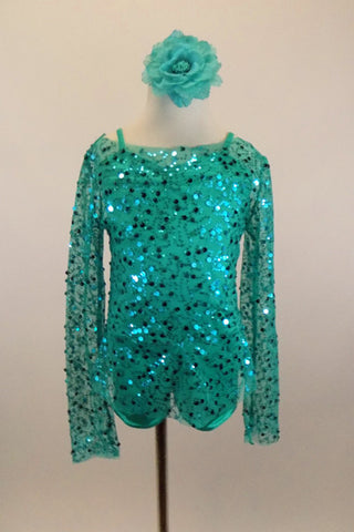 Aqua camisole biketard  has a matching sheer sequined long sleeved loose fit top that acts as a light cover and accent piece. Comes with floral  hair accessory. Front