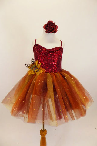 Rich earth-tone tutu dress has burgundy sequined bodice. Skirt is glitter ombré tulle over burgundy tulle layers with gold floral accent & hair accessory. Front