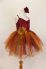 Rich earth-tone tutu dress has burgundy sequined bodice. Skirt is glitter ombré tulle over burgundy tulle layers with gold floral accent & hair accessory.  Right side