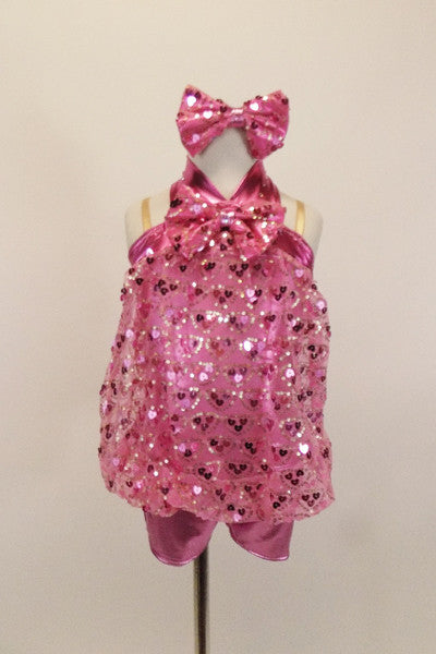 Heart sequin pink blouson top is attached to a metallic pink biketard with metallic yolk & halter straps. Has large sequined bow tie & matching hair accessory. Front