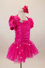 Hot pink stretch satin ruched dress has attached bolero with crystal accents,a  tulle skirt with silver polka dots & pouf sleeves. Comes with hair accessory. Right side