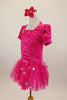 Hot pink stretch satin ruched dress has attached bolero with crystal accents,a  tulle skirt with silver polka dots & pouf sleeves. Comes with hair accessory. Left side