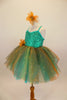 Aqua  jewel-tone tutu dress has sequin spandex front with cross straps. Skirt is glitter ombré tulle & soft aqua  beneath. Has gold flower at waist & for hair. Left side