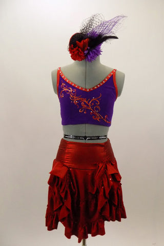 Shiny red ruffled layer skirt has matching purple bra top has red piping accent, red lace-up corset back & front with hand painted swirls and crystals. Comes with matching hair accessory. Front