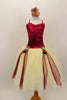 Wine colored crush velvet bodice, has attached cream tulle skirt with wine colored ribbon attached to rose clusters cascading at sides. Has floral hair accessory. Front
