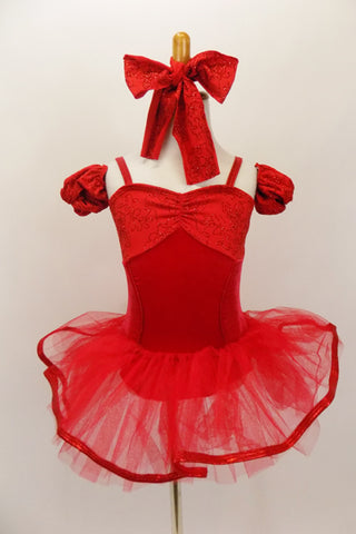 Red princess-cut camisole leotard has floral pattern bust area and matching arm poufs. There is a red pull-on tutu skirt with ribbon edging & matching hair bow. Front