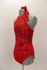 Red leotard has halter style front with open back, neck closure & vertical straps. Bodice is sheer with sequined sweetheart bust & bottom is solid red with applique accents. Side 