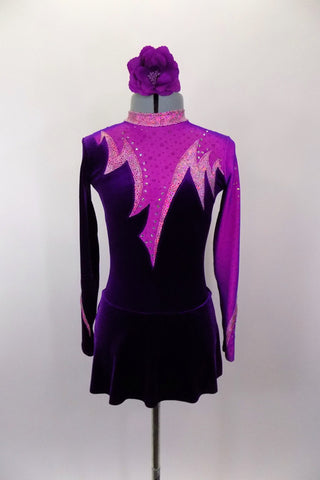 Unique purple velvet skater’s dress has intricate pink spike design on bodice front and back with crystal accents & keyhole back. Sleeves are alternate color of purple-pink . Comes with floral hair accessory. Front