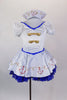 White sailor dress has princess cut seams, pouf sleeves and gold sailor buttons and hand painted anchor design over blue lace petticoat. Comes with sailor hat. Front