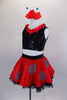 Ladybug themed costume has red skirt with large crystaled blue dots over layers of black lace petticoat. Comes with black sequin top & matching hair accessory. Left side